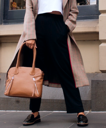 Modelo segurando uma bolsa camel
