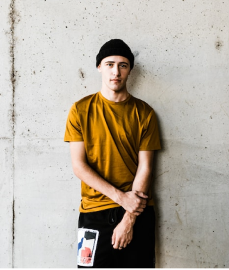 Modelo masculino com camiseta na cor mostarda